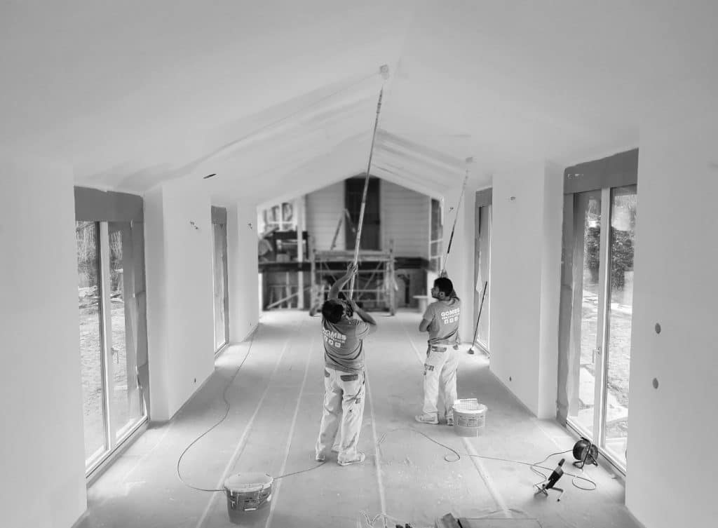 Peintres de Gomes SARL appliquant une peinture au plafond dans une maison en rénovation.