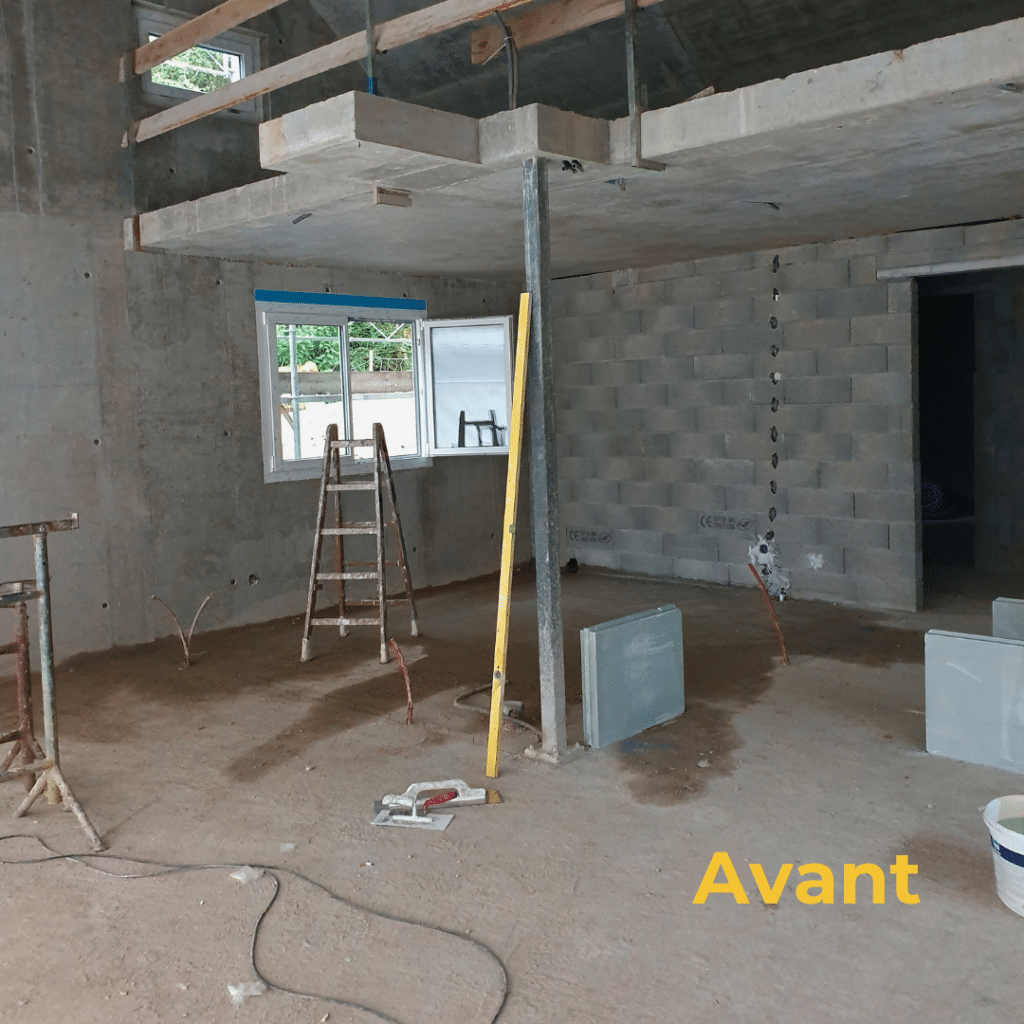 Intérieur brut en béton avec échafaudage et ouvertures avant rénovation.