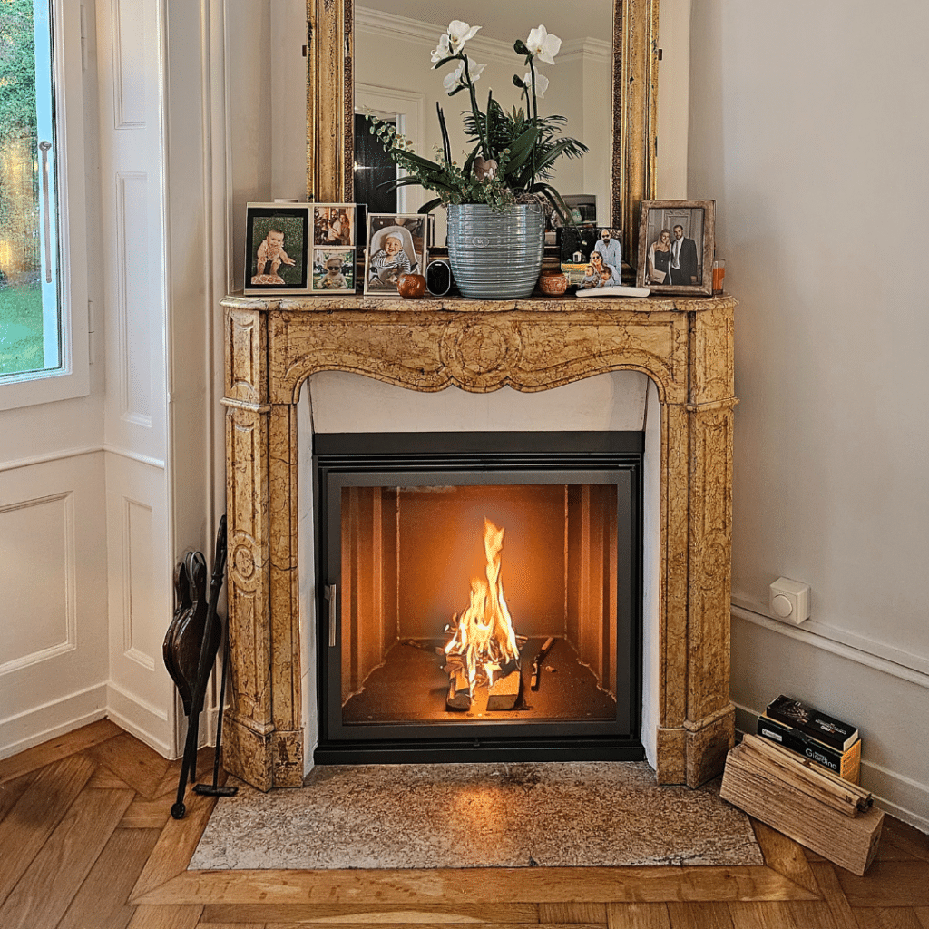 Insert sur mesure avec cadre doré classique avec feu de bois allumé.