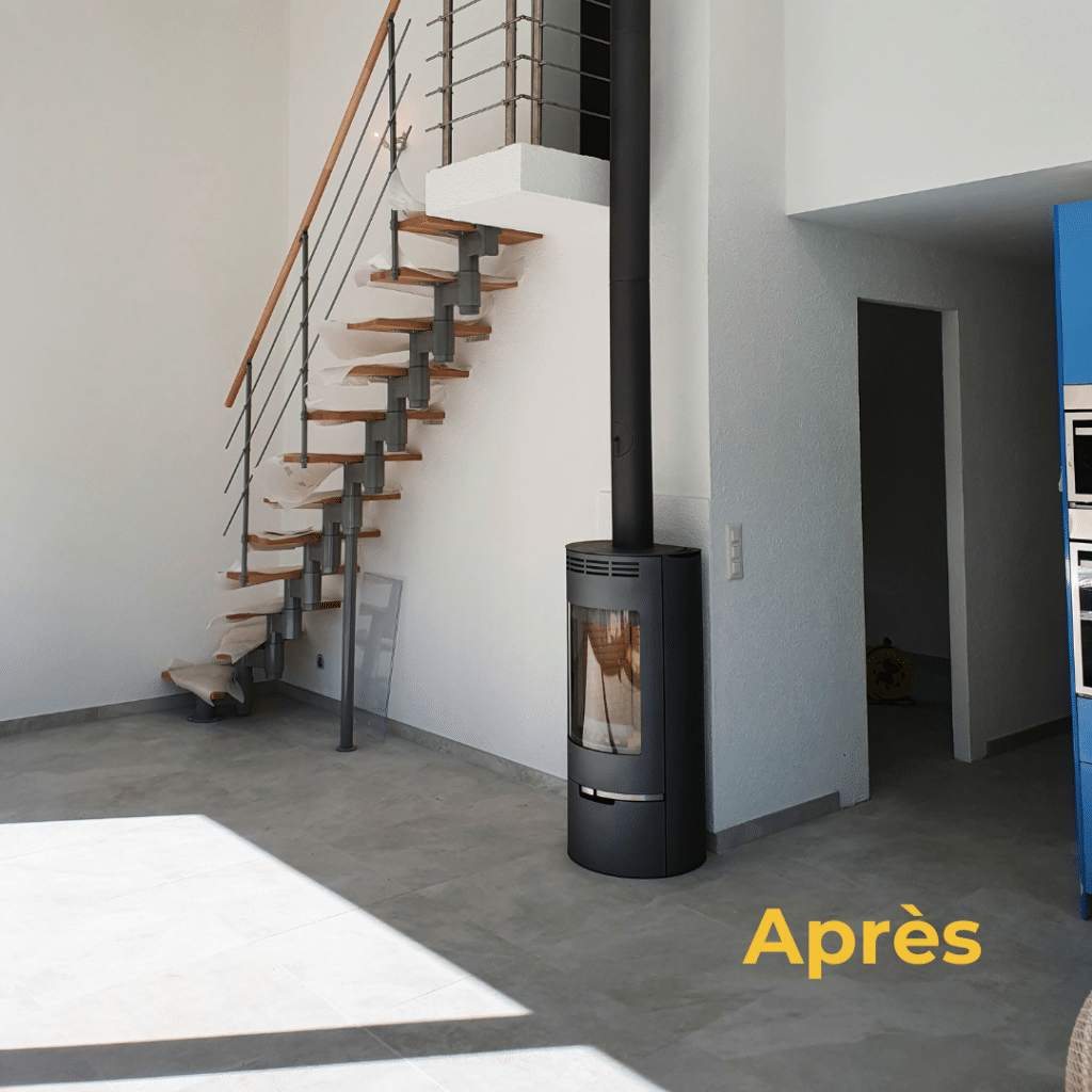 Intérieur rénové avec escalier design en bois et métal, poêle moderne et finitions claires.