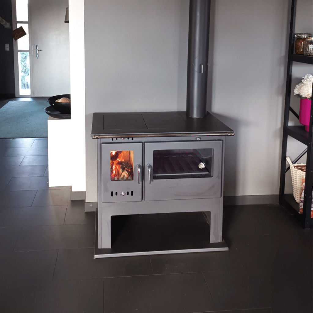 Cuisinière à bois en acier avec four intégré et compartiment de chauffage.