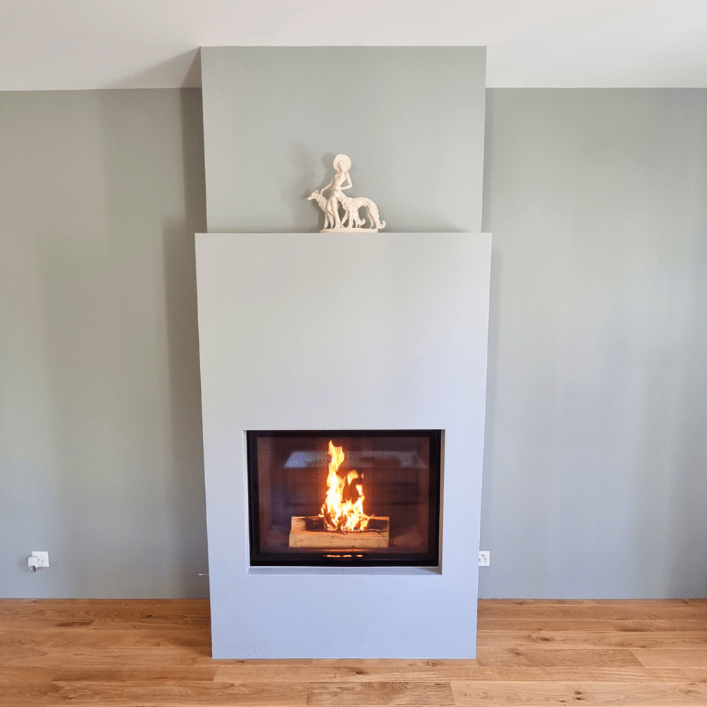 Cheminée moderne et minimaliste avec finition gris clair et feu chaleureux.