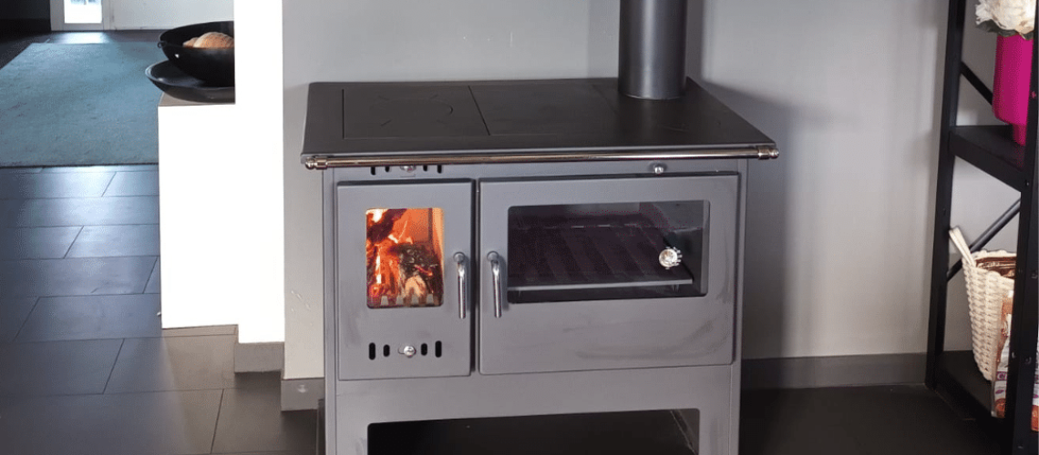 Cuisinière à bois en acier avec four intégré et compartiment de chauffage.